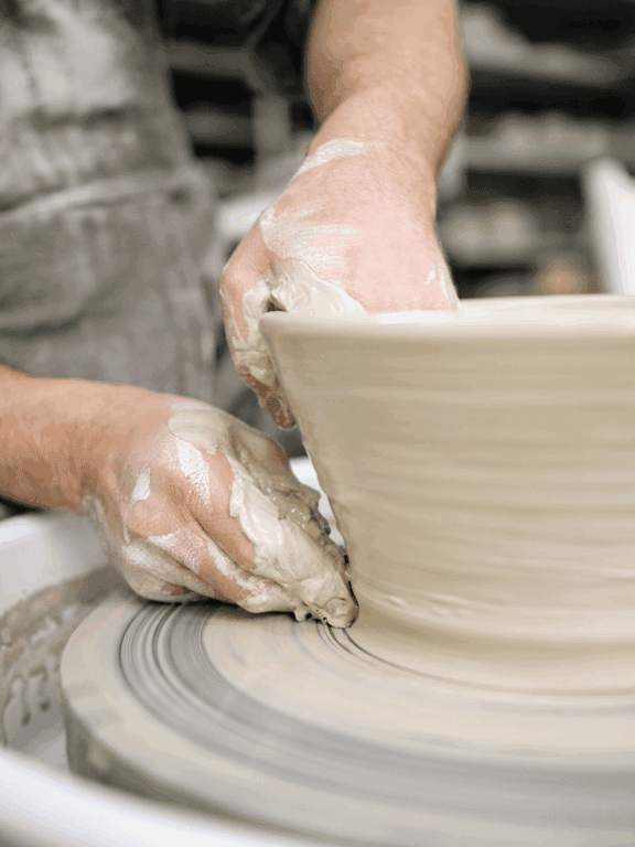 Handwerkskunst beim Töpfern auf der Töpferscheibe, kreative Keramikgestaltung, handgefertigte Töpferwaren, Kunsthandwerk aus Ton, kreative Keramikdesigns.